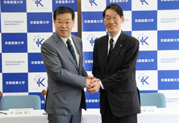 辞令交付式で、大城学長と握手。